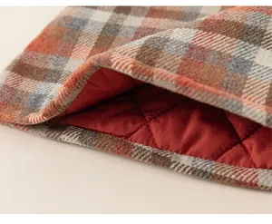 Detail of girls plaid wool dress featuring thick red quilted lining for winter warmth