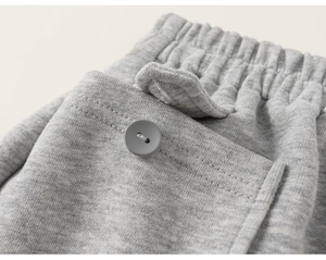 Détail du jogging gris pour enfant avec taille élastique et poche à bouton gris mat