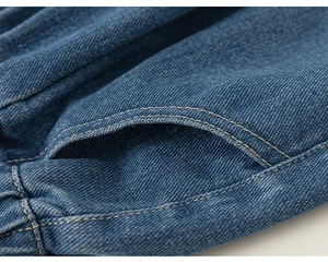Dettaglio dei jeans da bambina con cuciture della tasca e filo arancione a doppia cucitura