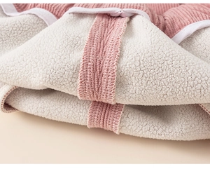 Detail of pink corduroy fabric with thick cream fleece lining for warm kids pants