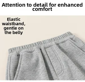 Detail of grey athletic trousers featuring a wide elastic waistband for kids