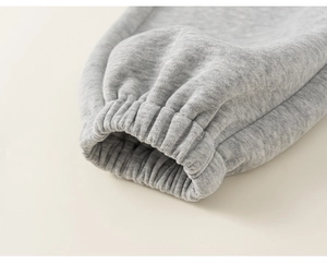 Détail du bas de jogging gris pour enfants avec ourlet élastique et texture de tissu doux