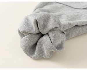 Gros plan du poignet en tricot gris chiné avec coutures précises pour vêtements d'enfants