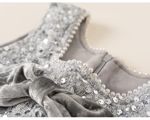 Detail of silver sequin tweed dress with pearl trim and grey velvet bow accent