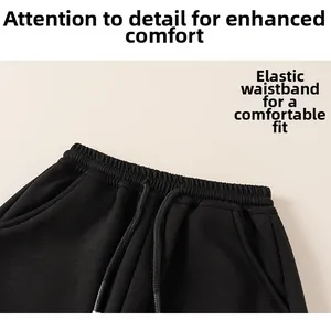 Detail of children's black joggers showing elastic waistband and drawstring texture