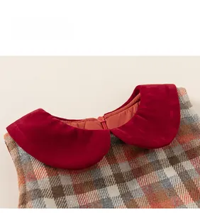 Close-up of red velvet Peter Pan collar and plaid fabric with invisible zipper detail