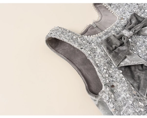 Detail of silver sequin tweed dress with velvet bow and elegant pearl neckline