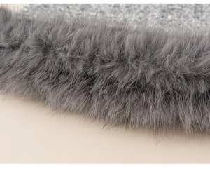 Detailed macro view of the grey faux fur trim and glittery textured fabric on girls' dress