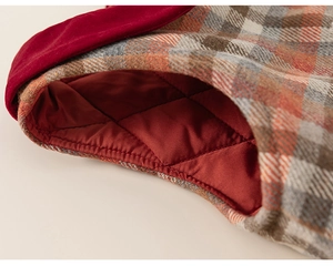 Detail of girls' plaid winter dress with red quilted lining and velvet trim