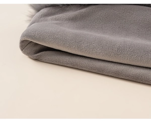 Detailed macro view showing the thick grey plush fabric and soft faux fur trim texture