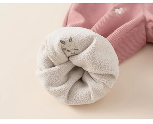 Detail of pink corduroy pants showing warm fleece lining and rabbit embroidery