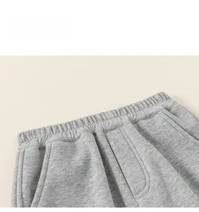 Detailed view of elastic waistband and pocket stitching on gray kids jogger pants