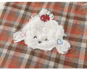 Detailed macro view of plaid fabric with lamb wool cartoon patch and cute embroidery