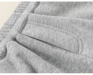 Detailed macro view of the elastic waistband and pocket stitching on gray cotton joggers