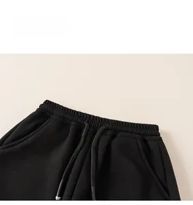 Detail of children's black joggers showing elastic waistband with drawstring and side pocket