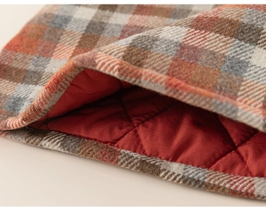 Close-up of girls' plaid dress showing thick wool-like fabric and quilted lining texture