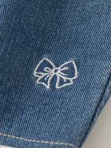 Jeans dritti da bambina con ricamo a fiocco bianco e dettagli in pizzo fine