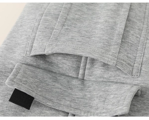 Macro detail of a grey knit sports trouser featuring a functional cargo pocket and velcro