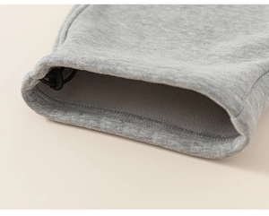 Detailed macro view of gray fleece-lined knit pants with adjustable elastic drawstring cuff