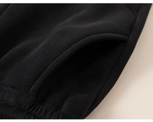 Close-up of black children's jogger pants showing pocket detail and soft knit fabric texture