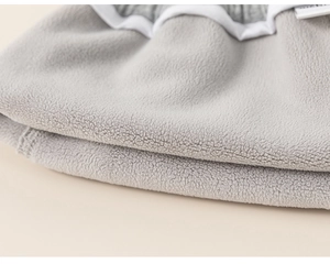 Close-up of soft grey polar fleece fabric texture and white elastic hem on winter pants