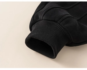 Detail view of the ribbed cuffs on boys' black winter joggers with premium stitching
