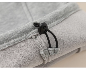 Detail view of adjustable drawstring toggle and soft fleece lining on gray kids jogger pants