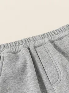 Close-up of boys gray athletic joggers featuring elastic waistband and soft knit fabric