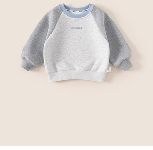 Detalle de sudadera infantil con mangas ranglán, cuello redondo y suave textura de algodón
