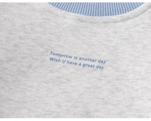 Detalle de sudadera gris para niños con cuello azul y texto de diseño impreso