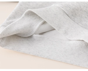 Vista detallada del forro polar cálido y el dobladillo acanalado de la sudadera gris infantil