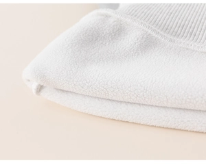 Primer plano del suave forro polar blanco y puño de punto acanalado de sudadera niña