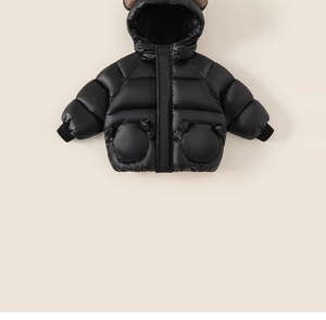 Detail of black waterproof puffer jacket for kids with cute ear hood and windproof cuffs