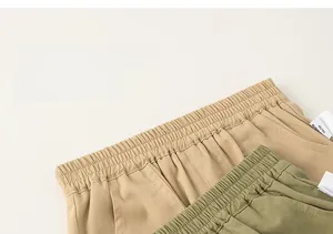 Detail view of elastic waistbands on khaki and olive green kids cotton casual pants