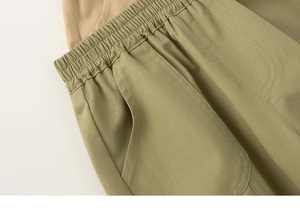 Detail of boys' olive green trousers featuring an elastic waistband and side pockets