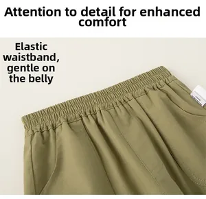 Detail of olive green kids leisure pants showing elastic waistband and side pocket