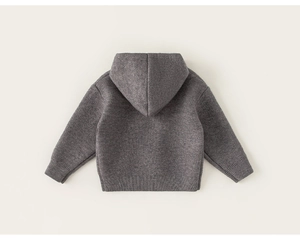 Dettaglio della trama del maglione grigio scuro con cappuccio e polsini a coste bimbo
