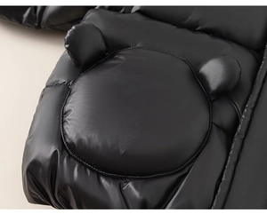 Detail of a black shiny waterproof kids jacket featuring cute 3D bear ears on the hood