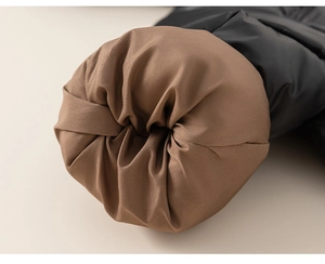 Close-up of windproof black fabric and brown silk texture lining on children's coat sleeve
