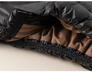 Macro detail of glossy black windproof jacket hem with elastic cuff and brown satin lining