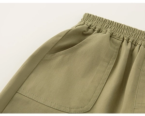 Detailed close-up of olive green kids casual trousers with elastic waist and side pocket