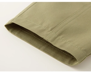 Macro shot of olive green twill fabric trousers with professional double-stitched hem finish