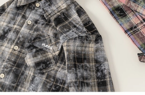 Detail view of boys plaid flannel shirt showing breast pocket with need embroidery