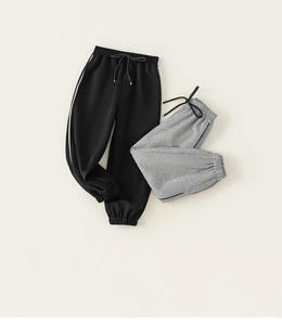 Detailansicht der Kinder-Jogginghose mit elastischem Bund und Seitenstreifen in Schwarz und Grau