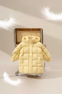 Detail of a bright yellow kids puffer jacket with quilted design and soft feather accents