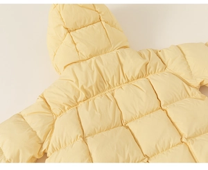 Close-up of pale yellow hooded down jacket with square quilting for kids warmth