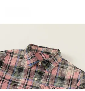 Detail of plaid cotton shirt featuring colorful check patterns and round white buttons