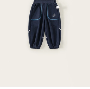 Detail of navy kids joggers featuring elastic waist and reflective stripe on leg