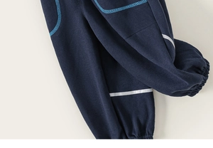 Detail of navy blue kids' joggers featuring reflective silver stripes and cuffed ankles