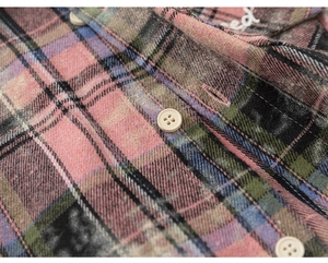 Close-up of plaid kids shirt with beige buttons and white letter embroidery detail